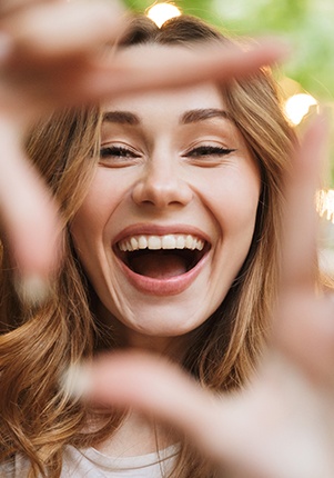 Young woman showing off smile after full mouth reconstruction