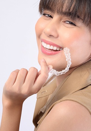 Woman holding Invisalign aligners