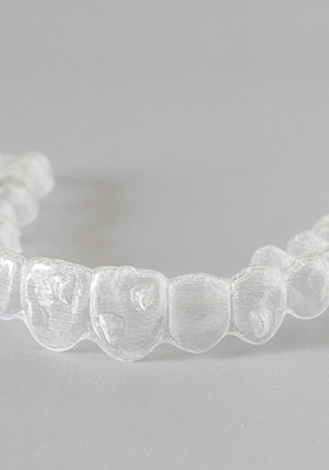 Clear aligner lying on grey surface