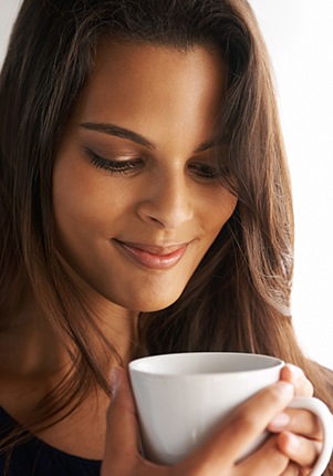Woman drinking coffee which can discolor teeth