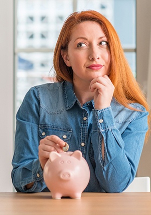 Woman putting coin in piggy bank