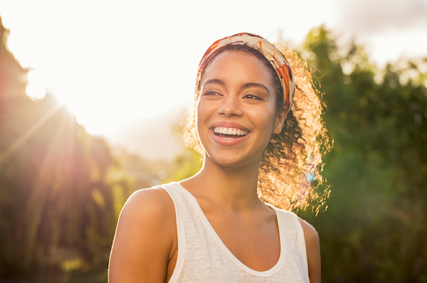 attractive woman smiling in front of setting sun