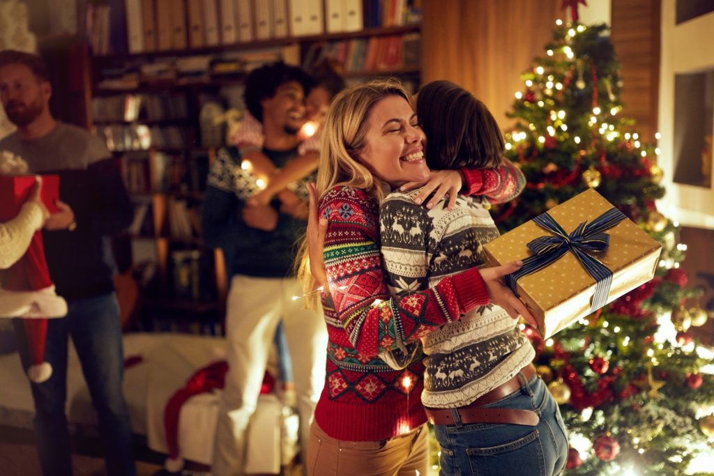 Smiling woman hugging friend at holiday party